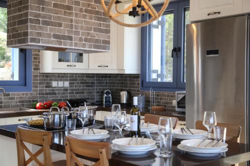 a kitchen with a table with chairs and a dining room at Villa LeSunLuka Lefkada in Vasiliki