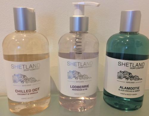two bottles of detergent sitting next to each other at Rowanlea Lodge With Hot Tub in Marykirk