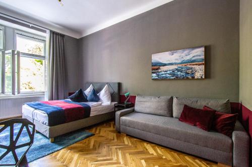 a living room with a bed and a couch at Garden Apartments in Prague