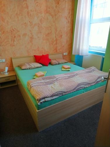 a bedroom with a large bed with a window at Penzion Volyňka in Vimperk