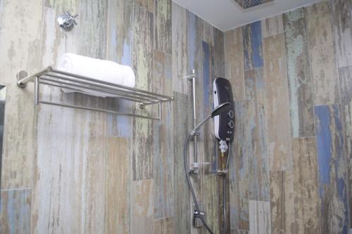 a bathroom with a shower with a phone on the wall at Rest And Comfort Boutique Hotel in Kuala Terengganu