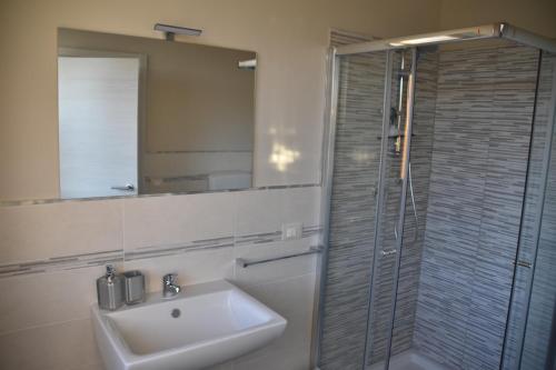 La salle de bains est pourvue d'un lavabo et d'une douche en verre. dans l'établissement La Culla del Mugello, à Scarperia