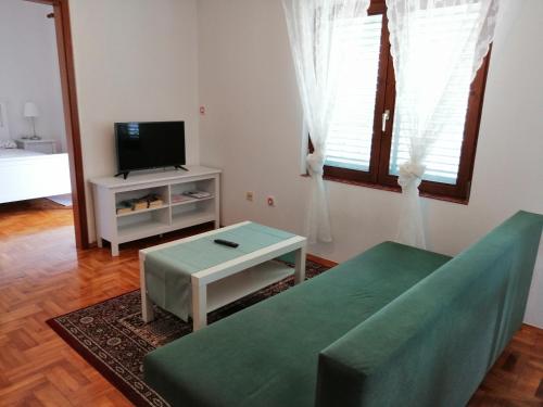 a living room with a couch and a tv at Apartments Kati in Orebić