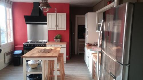 a kitchen with a refrigerator and a table in it at LE JABLOIRE in Florent-en-Argonne