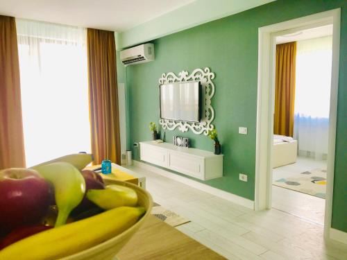a living room with a mirror on a green wall at DarNiDa Luxury Apartment in Mamaia Sat/Năvodari