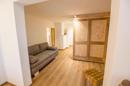 a living room with a couch and a sliding door at Pension Tannenhof in Leogang