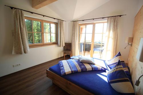 a bedroom with a bed and a large window at Pension Tannenhof in Leogang