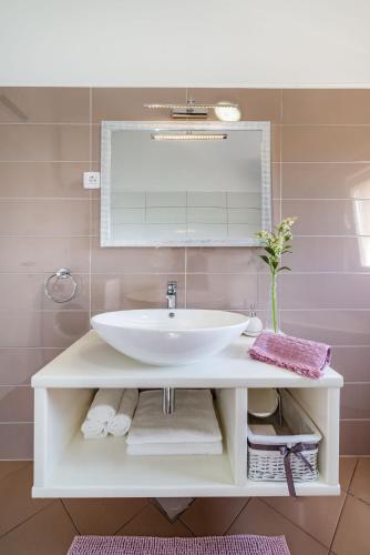 a bathroom with a sink and a mirror at Apartman ZOZZY in Posedarje