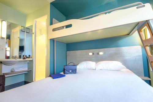 - une chambre avec des lits superposés et un mur bleu dans l'établissement ibis budget Marseille L'Estaque, à Marseille