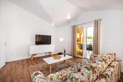a living room with a couch and a tv at Apartman ZOZZY in Posedarje