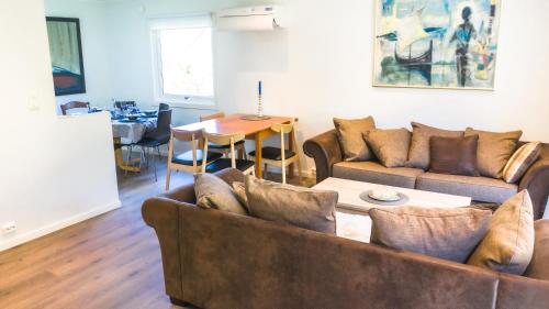 a living room with two couches and a table at Krossmyrhill. Great house in Eik
