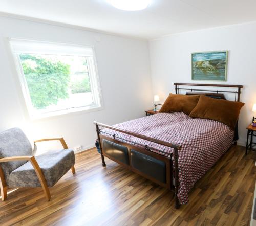 a bedroom with a bed and a chair and a window at Krossmyrhill. Great house in Eik