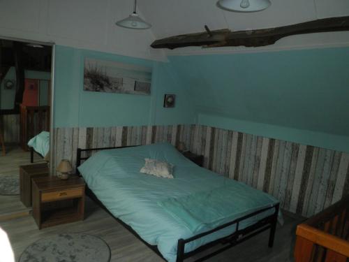 a bedroom with a bed in a room with blue walls at gîte le voyageur in Tours-en-Vimeu