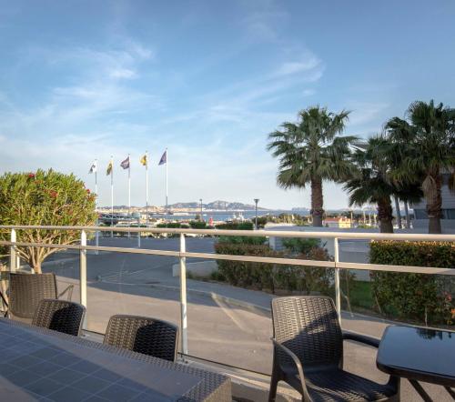 balcón con mesa, sillas y palmeras en ibis budget Marseille L'Estaque, en Marsella