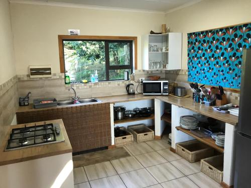 eine Küche mit einem Waschbecken und einer Theke mit einem Fenster in der Unterkunft Bamboo Room in Ponta do Ouro