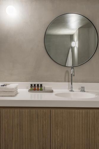 a bathroom with a sink and a mirror at Enigma Suites in Fira