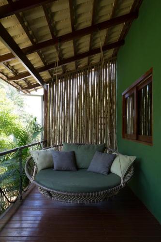 a wicker couch in a room with a porch at Casa da Lua Pousada in Alto Paraíso de Goiás