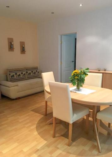 ein Wohnzimmer mit einem Tisch, Stühlen und einem Sofa in der Unterkunft Beach Paradise Apartments in Liepāja