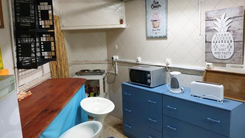 a kitchen with a blue counter with a microwave at Wish & Stay in Albufeira