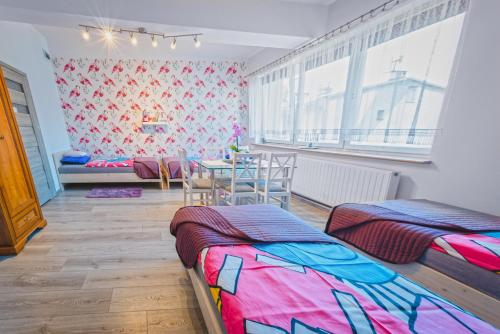 a room with two beds and a table in it at Frank Apartments - 5min Auschwitz, 15min Energylandia - Oswiecim Center in Oświęcim