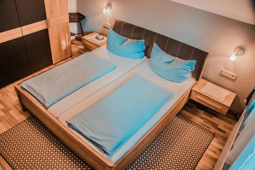a large bed in a small room with blue pillows at Ferienhaus Arneitz in Faak am See