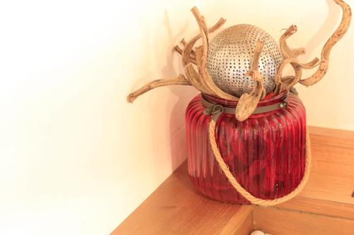 a red vase sitting on top of a shelf at Pension Tannenhof in Leogang