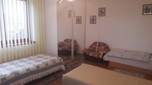 a room with two beds and a chair and a table at Ladislav in Spišské Vlachy