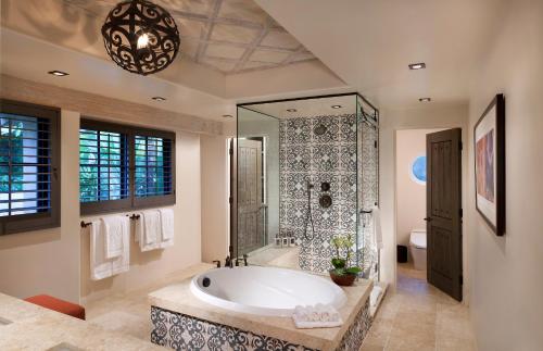Rancho Valencia Resort and Spa في رانشو سانتا في: حمام مع حوض استحمام كبير ودش