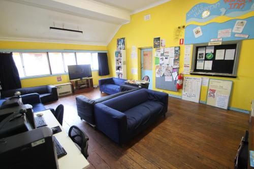 a living room with blue couches and a tv at Wander Inn Bunbury in Bunbury