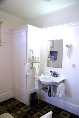 a white bathroom with a sink and a mirror at The Mosser Hotel in San Francisco