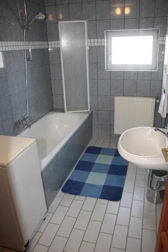 a bathroom with a tub and a sink at Fox Apartmanok in Hévíz