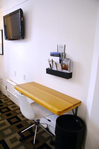 a desk with a chair and a tv on a wall at The Mosser Hotel in San Francisco
