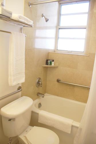 a bathroom with a toilet and a tub and a window at The Mosser Hotel in San Francisco