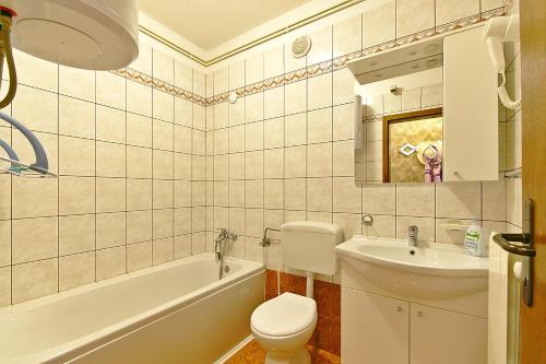 a bathroom with a toilet and a sink and a tub at Apartment Vesna in Novi Vinodolski