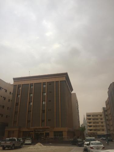 a large building with cars parked in a parking lot at Hotel Zayara in Riyadh