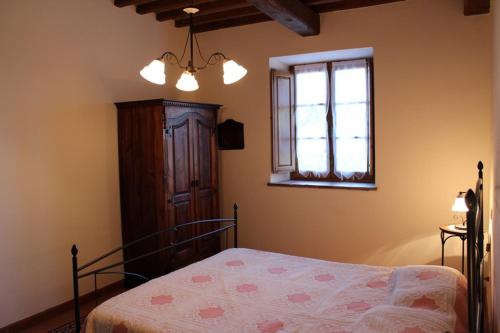 a bedroom with a bed and a window at Agriturismo La Quercia in Boccheggiano