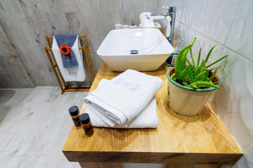 a bathroom with a sink and a table with towels at Great Alexander Suites in Sarandë