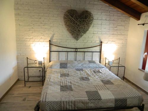 una camera da letto con un letto con un cuore sul muro di casa Grinovero a Cividale del Friuli