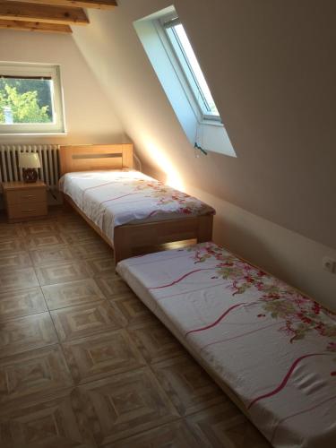 2 camas en una habitación con ventana en Apartmán Panoráma, en Banská Štiavnica