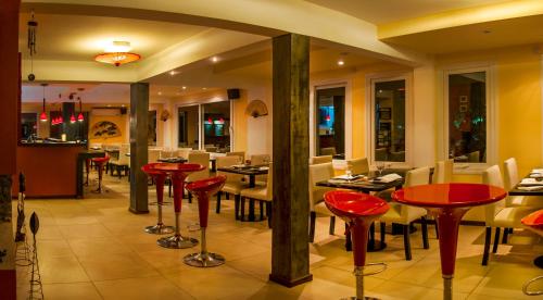 a restaurant with red tables and chairs in a room at Mizu Hotel Boutique in Mar de las Pampas