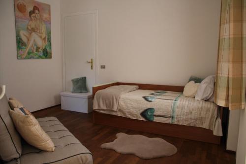 ein kleines Schlafzimmer mit einem Bett und einem Sofa in der Unterkunft Ca' Mirta in Caprino Veronese