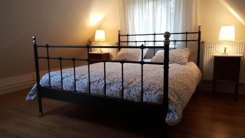 een bed in een slaapkamer met 2 lampen en een raam bij Vakantiewoning Deend in Laren