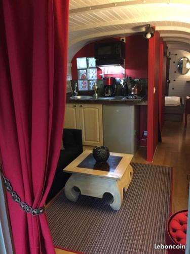 Sala de estar con cortina roja y mesa en ROULOTTE - LE DOMAINE DES ECREVISSES, en Saint-Florent-sur-Cher