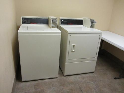 two washing machines sitting next to each other in a room at Country Inn & Suites by Radisson, Amarillo I-40 West, TX in Amarillo