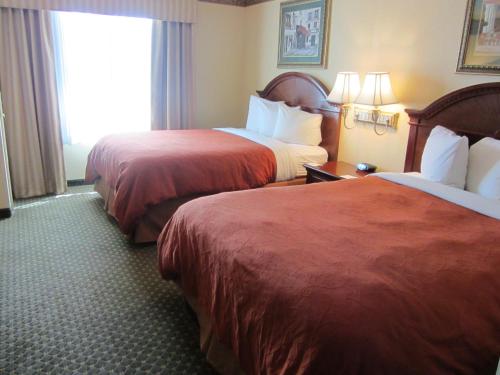 a hotel room with two beds and a window at Country Inn & Suites by Radisson, Amarillo I-40 West, TX in Amarillo