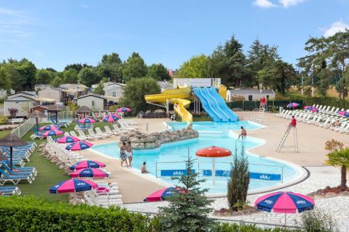 a pool at a water park with a slide at BARERO LOCATIONS DE MH PROCHE BEAUVAL ET CHATEAU DANS LOIRE et CHER in Onzain