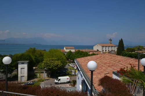 a view of a town with a white car parked in a parking lot at Hotel Enrichetta in Desenzano del Garda
