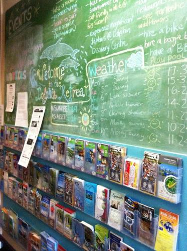 a chalkboard with a menu on a wall with books at Dolphin Retreat Bunbury in Bunbury