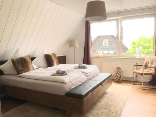 ein Schlafzimmer mit einem Bett und einem großen Fenster in der Unterkunft Luxuriöse 3-Zi. Ferienwohnung Jagdromantik 200 m bis zur Wurmbergsseilbahn in Braunlage
