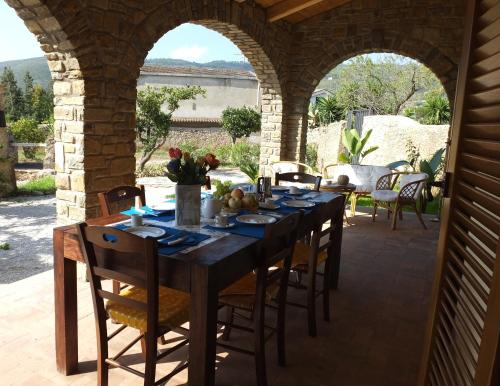 una mesa de comedor en una sala al aire libre con un arco en Casetta Clementina en Castellabate